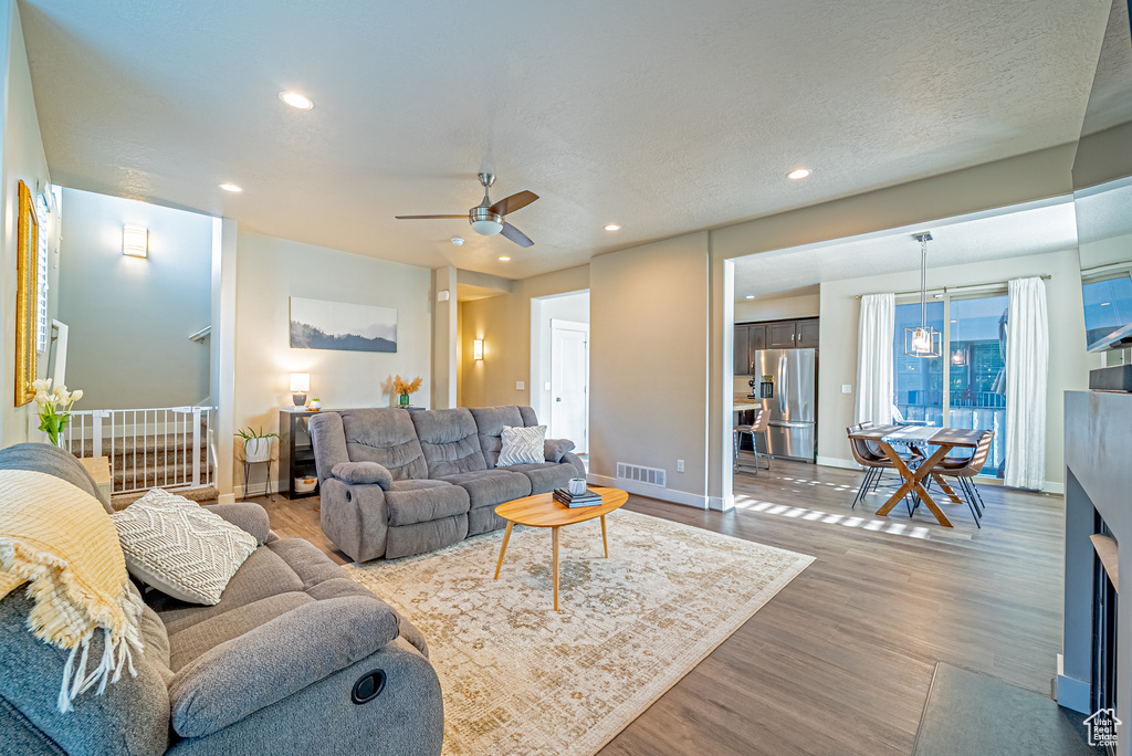 Living area featuring ceiling fan, wood finished floors, recessed lighting, and baseboards