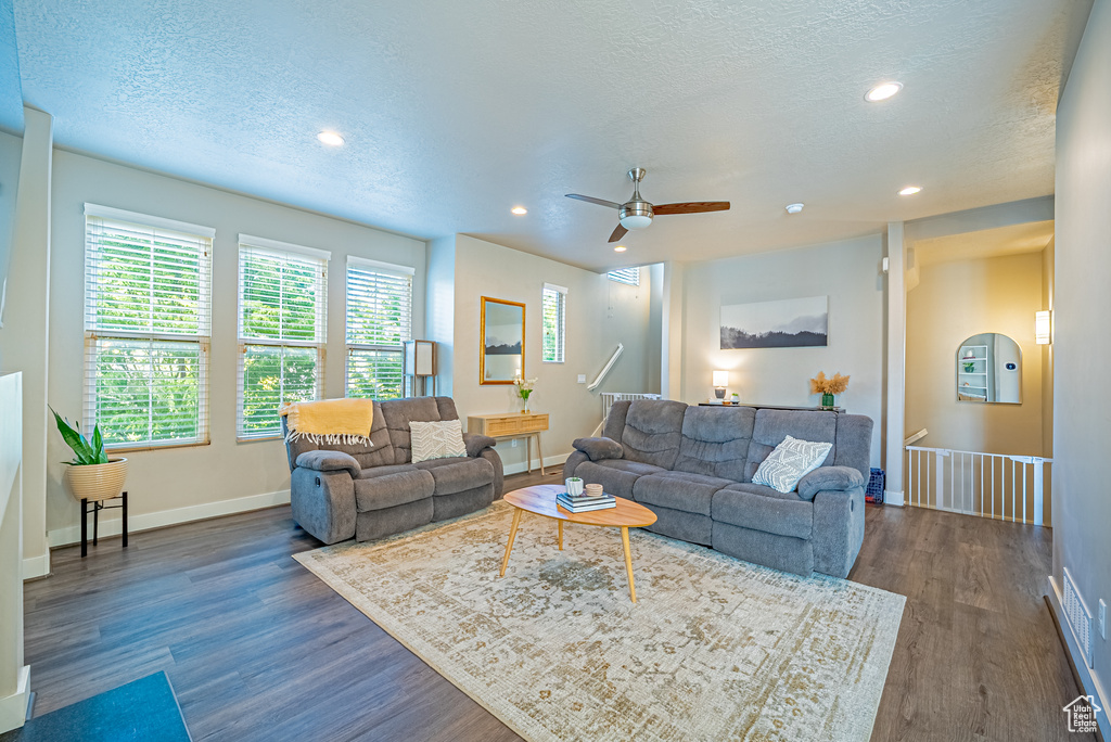 Living area featuring a textured ceiling, dark wood-style flooring, recessed lighting, ceiling fan, and baseboards