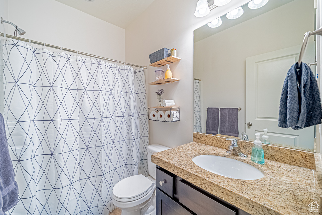 Full bathroom with toilet, vanity, and a shower with curtain