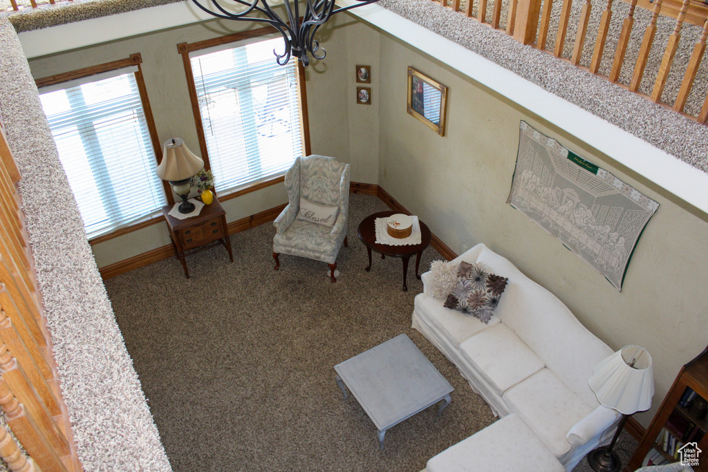 Living area featuring a chandelier, baseboards, and carpet floors