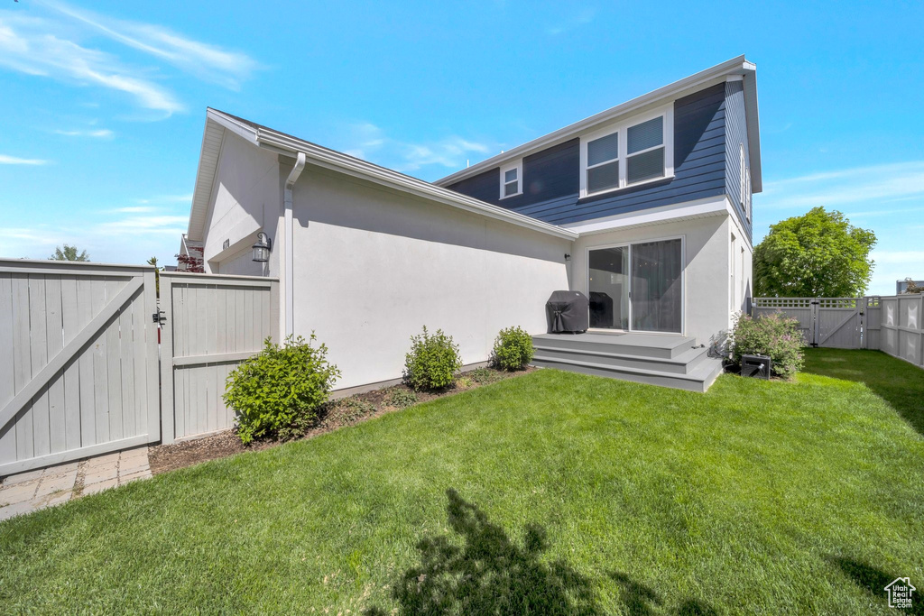 Rear view of house with a gate and stucco siding