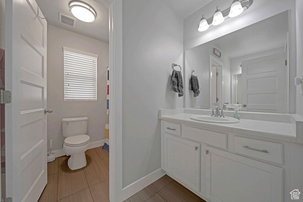 Bathroom with vanity, toilet, and baseboards