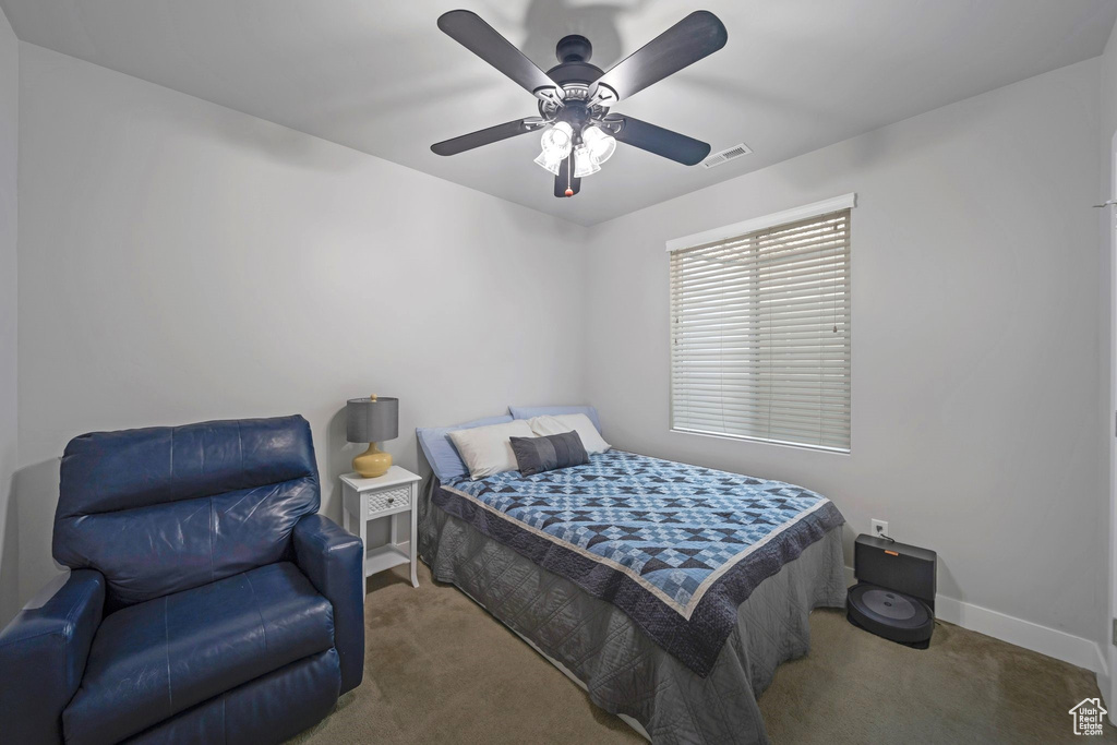 Bedroom with carpet flooring, baseboards, and a ceiling fan