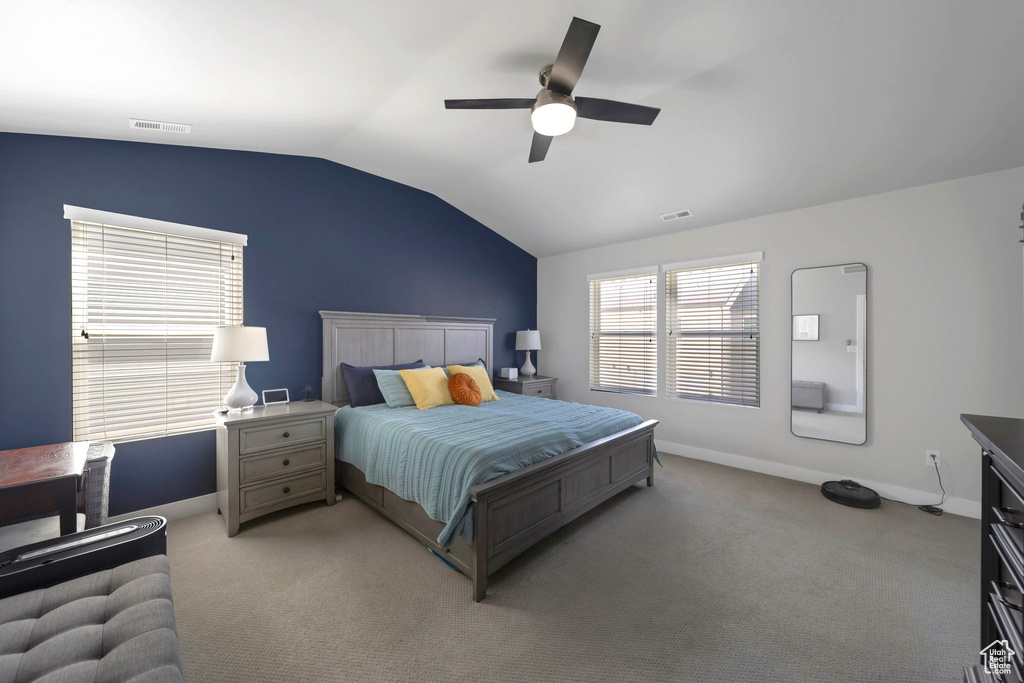 Bedroom with lofted ceiling, light colored carpet, baseboards, and ceiling fan