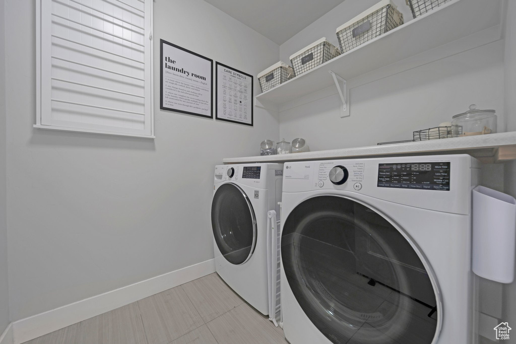 Laundry area featuring separate washer and dryer and baseboards