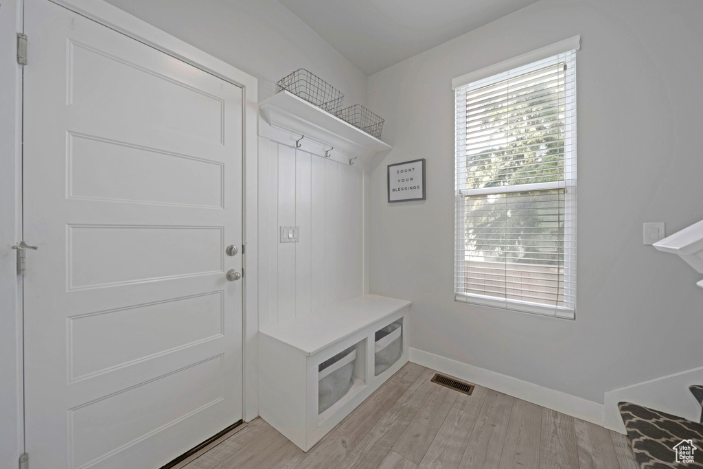 Mudroom with light wood finished floors and baseboards