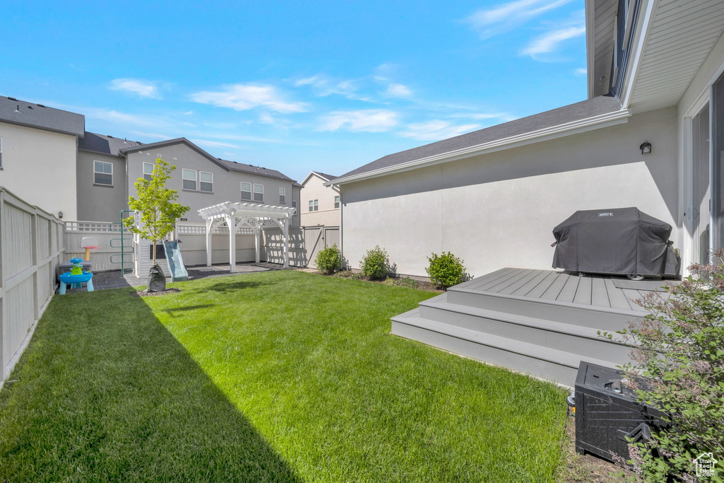View of yard featuring a pergola, a wooden deck, and a residential view