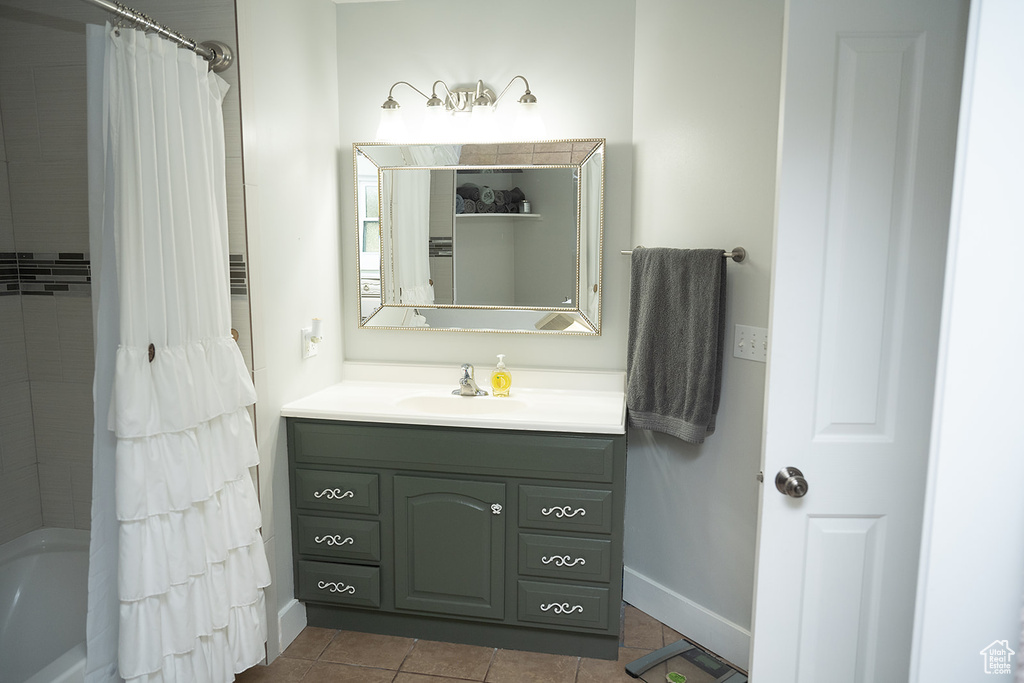 Bathroom featuring vanity, tile patterned flooring, and shower / bath combination with curtain