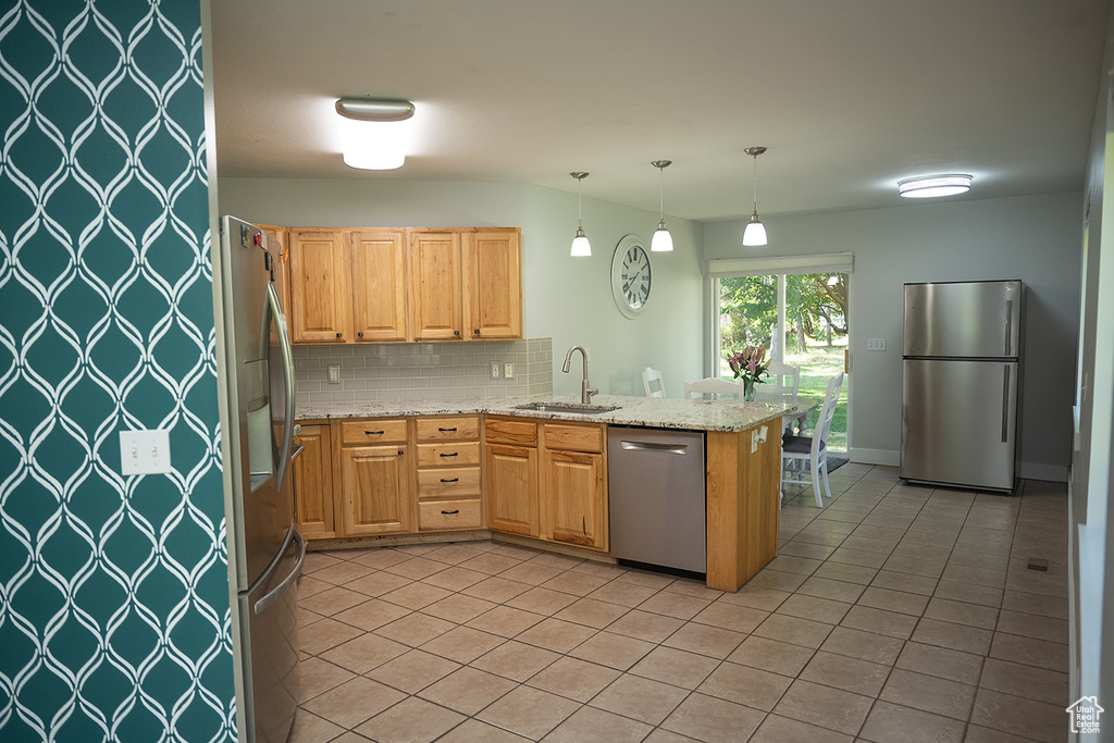 Kitchen featuring stainless steel appliances, decorative backsplash, light tile patterned floors, a peninsula, and decorative light fixtures
