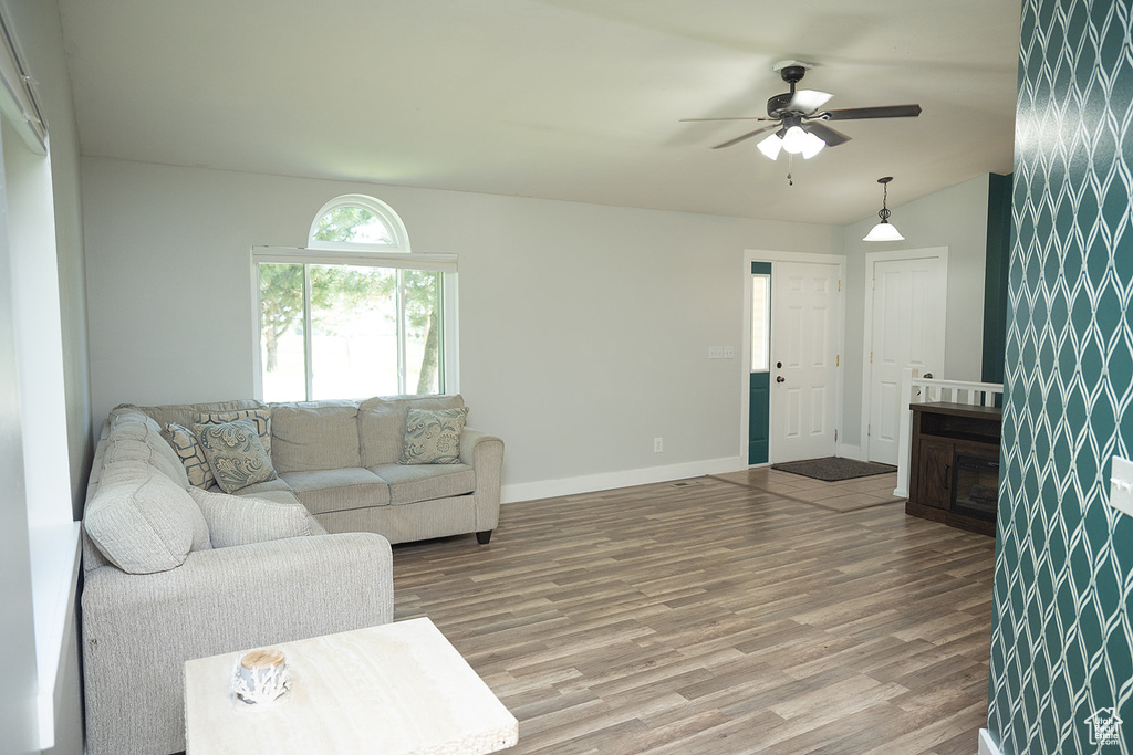 Living area with wood finished floors, a ceiling fan, and vaulted ceiling