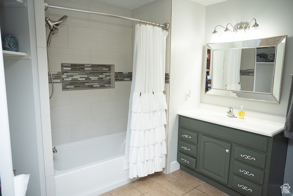 Full bathroom with tile patterned floors, shower / tub combo with curtain, and vanity
