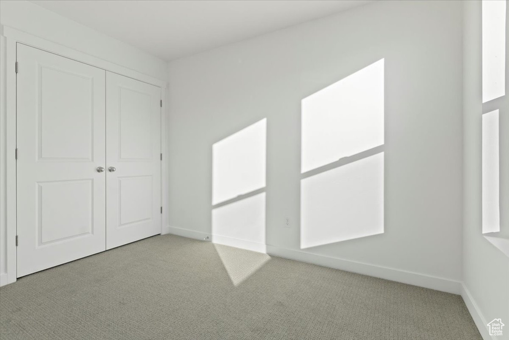 Unfurnished bedroom featuring carpet flooring, baseboards, and a closet