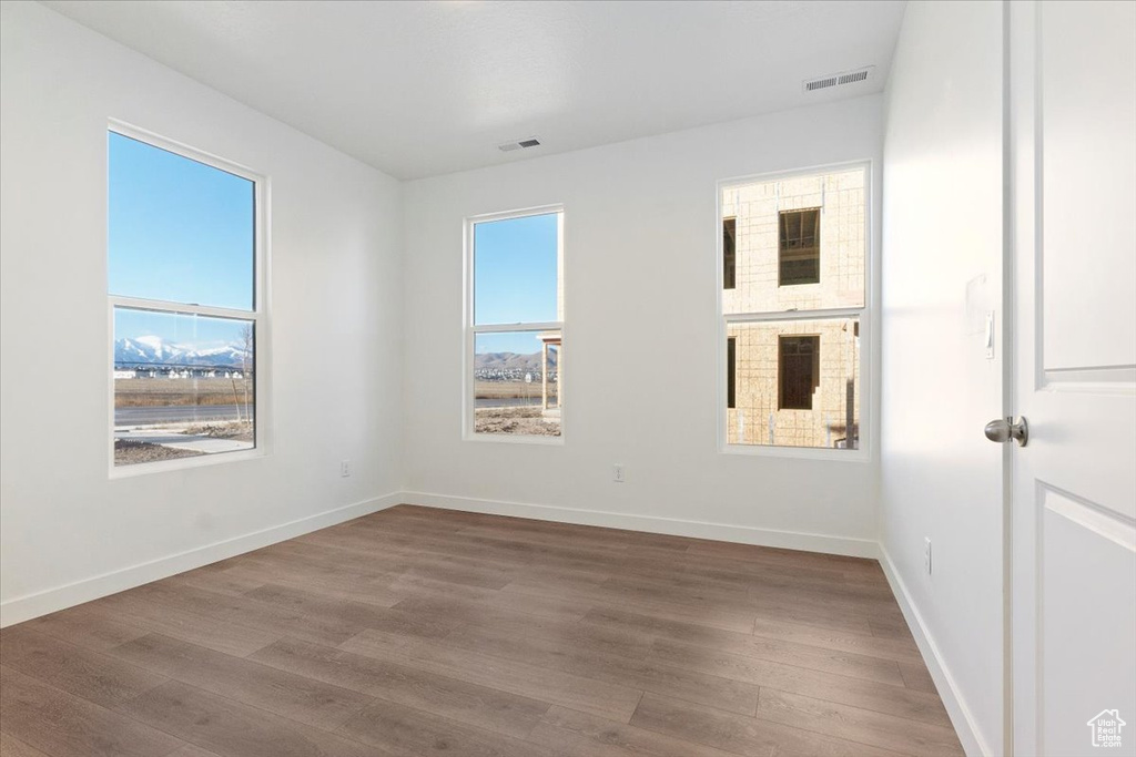 Unfurnished room featuring wood finished floors and baseboards