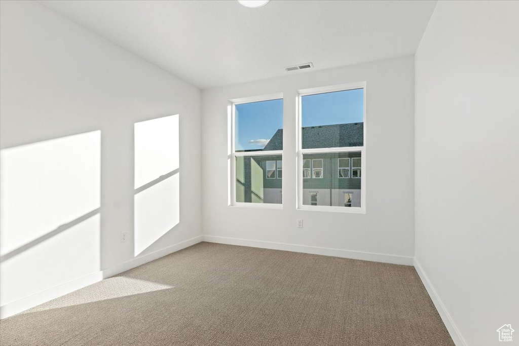 Carpeted empty room featuring baseboards