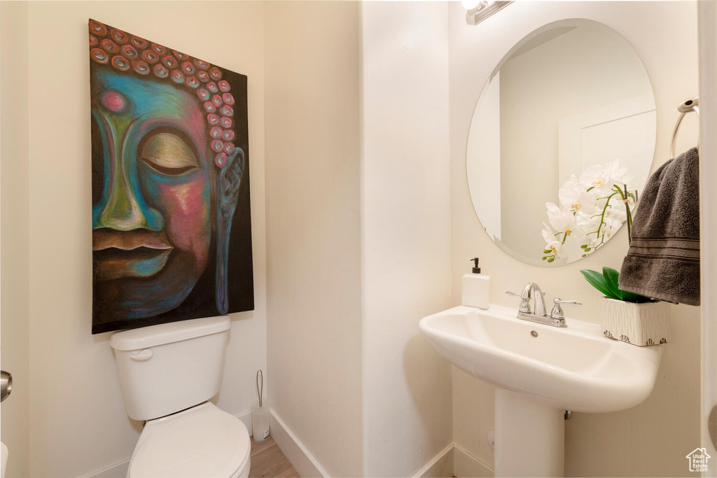 Half bathroom featuring toilet and baseboards