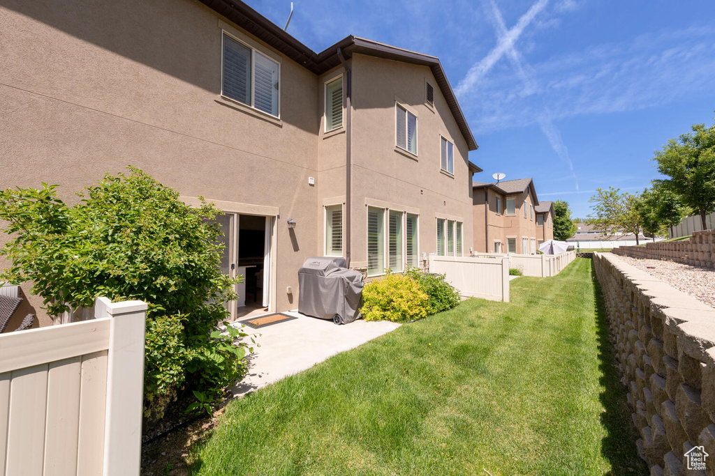 Back of property with stucco siding, a patio, and a residential view