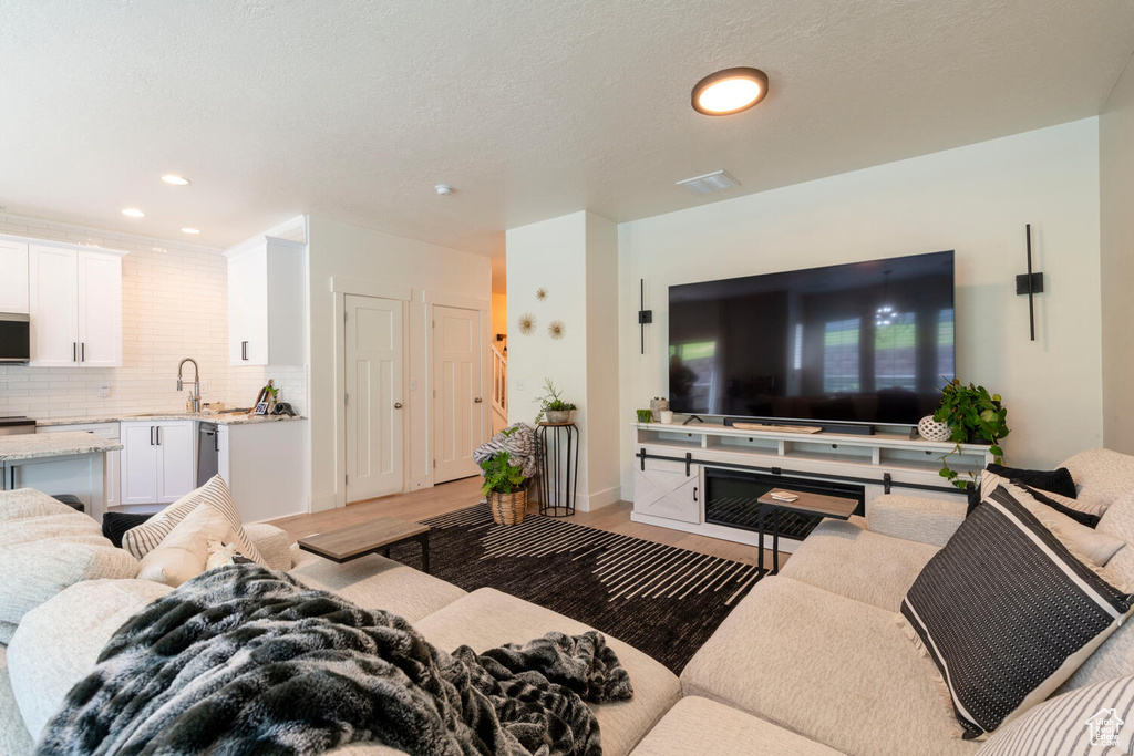 Living area featuring light wood-style floors and recessed lighting