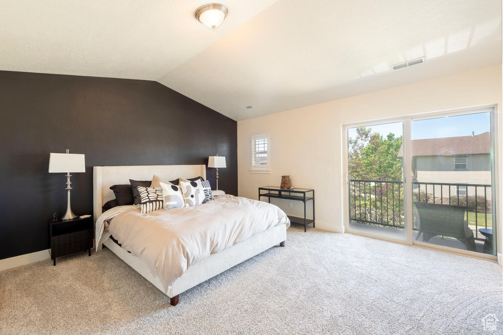 Bedroom featuring access to outside, light colored carpet, vaulted ceiling, and baseboards