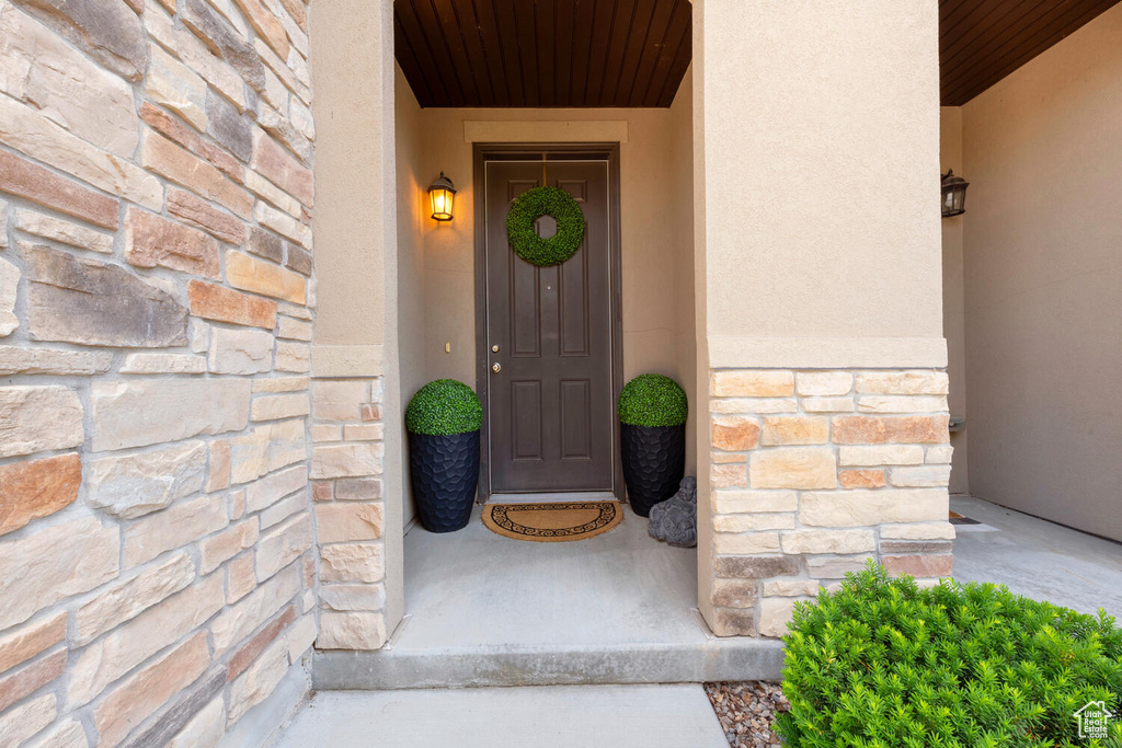 Entrance to property with stone siding and stucco siding