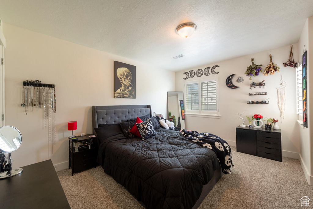 Bedroom with light colored carpet and baseboards