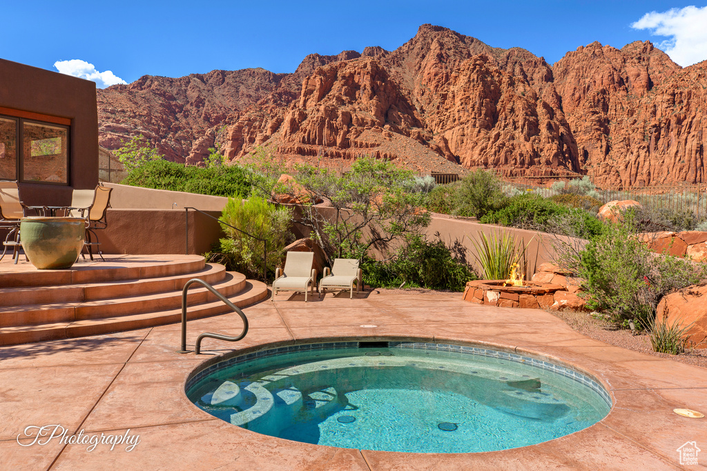 View of swimming pool featuring an in-ground hot tub, a patio area, a mountain view, and a swimming pool
