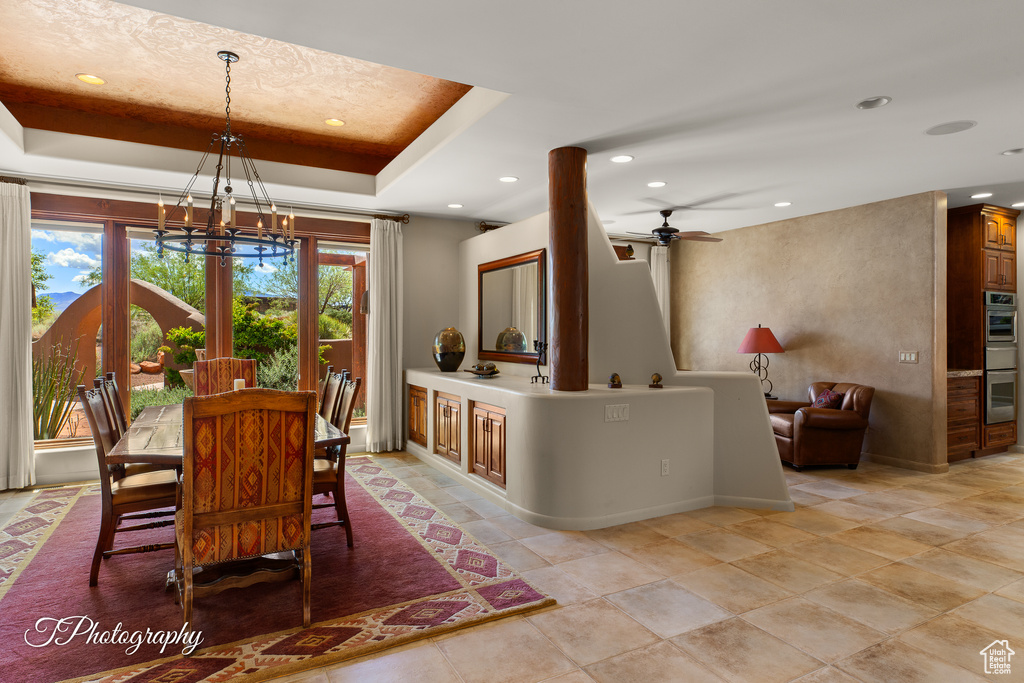 Dining room featuring a chandelier, recessed lighting, baseboards, a raised ceiling, and ceiling fan