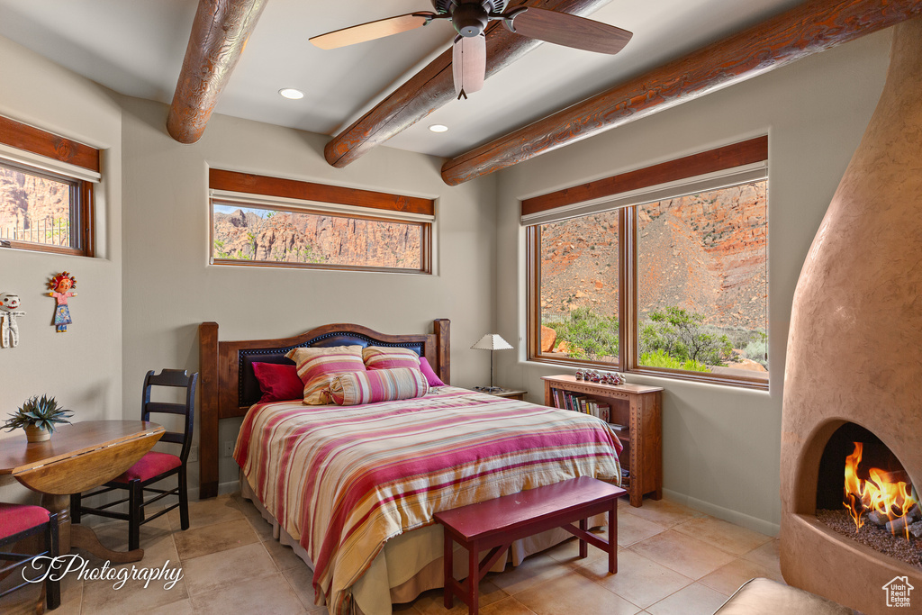 Bedroom featuring beamed ceiling, multiple windows, recessed lighting, baseboards, and light tile patterned flooring