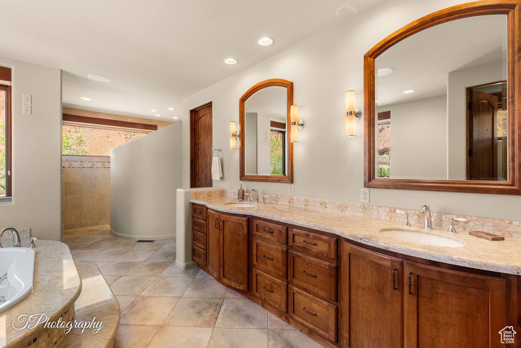Bathroom with double vanity, tile patterned floors, a tub, recessed lighting, and tiled shower