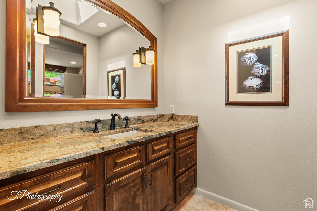 Bathroom with vanity, baseboards, and tile patterned floors