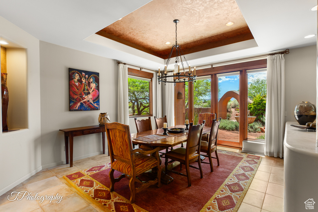 Dining space featuring a chandelier, a tray ceiling, light tile patterned flooring, recessed lighting, and baseboards