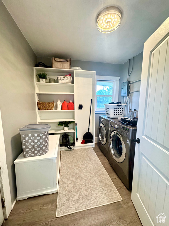 Laundry room with independent washer and dryer, wood finished floors, and electric panel