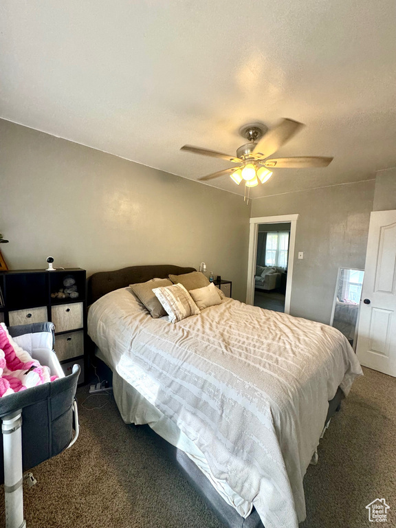 Carpeted bedroom with a ceiling fan