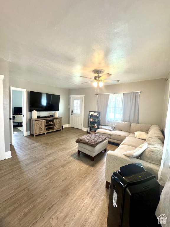 Living area featuring ceiling fan, light wood-style flooring, and baseboards