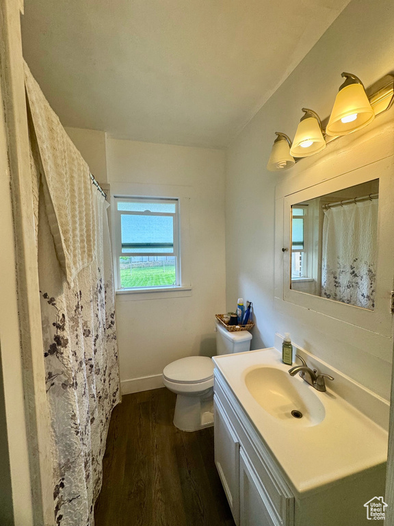 Full bathroom featuring toilet, wood finished floors, vanity, and baseboards