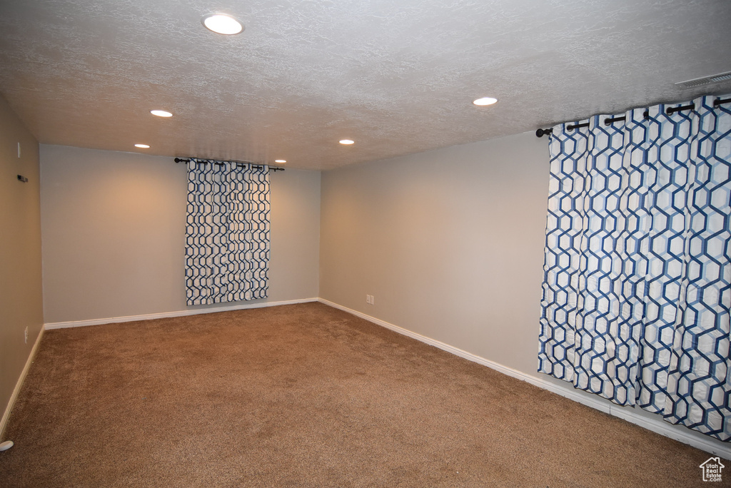 Spare room featuring recessed lighting, carpet floors, a textured ceiling, and baseboards