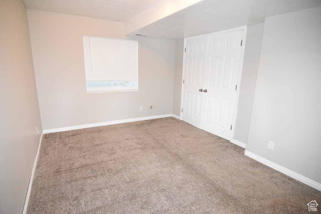 Unfurnished bedroom with carpet, baseboards, and a closet