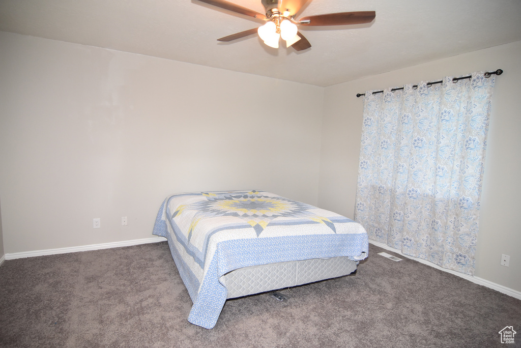 Bedroom with carpet flooring, baseboards, and a ceiling fan