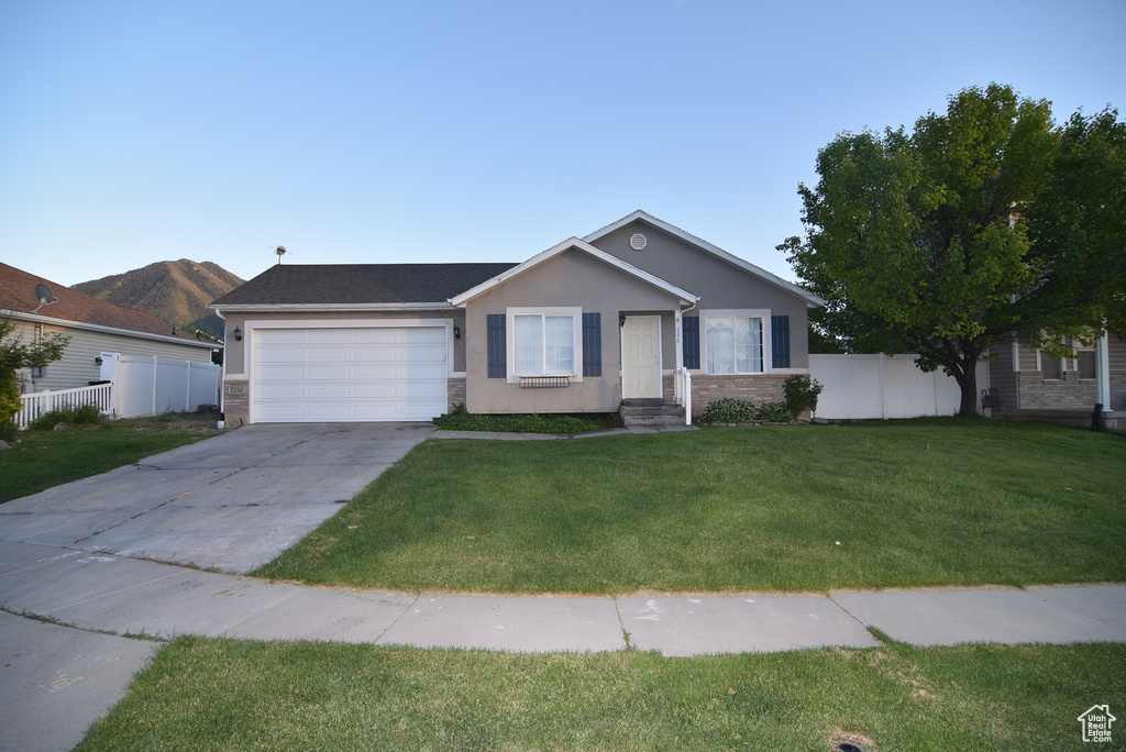 Ranch-style house featuring an attached garage, driveway, and stucco siding