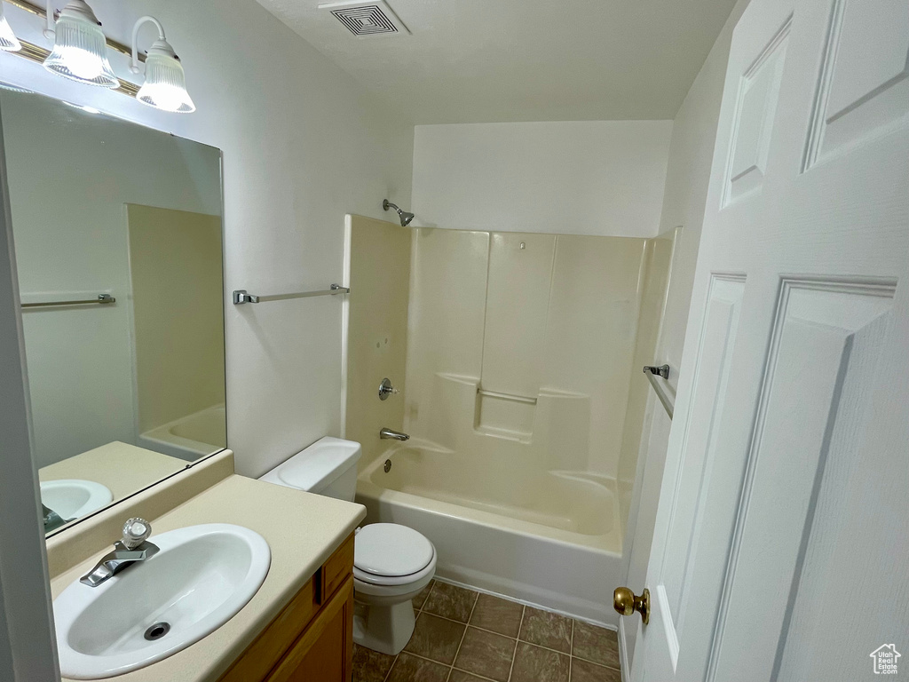 Bathroom with bathtub / shower combination, vanity, and tile patterned floors