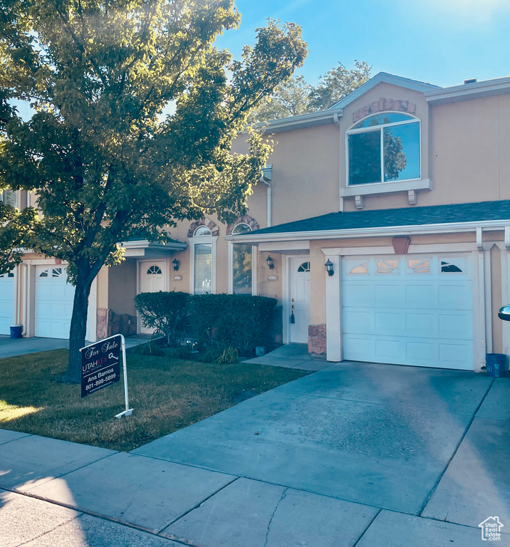 View of front of house featuring stucco siding, a garage, and concrete driveway