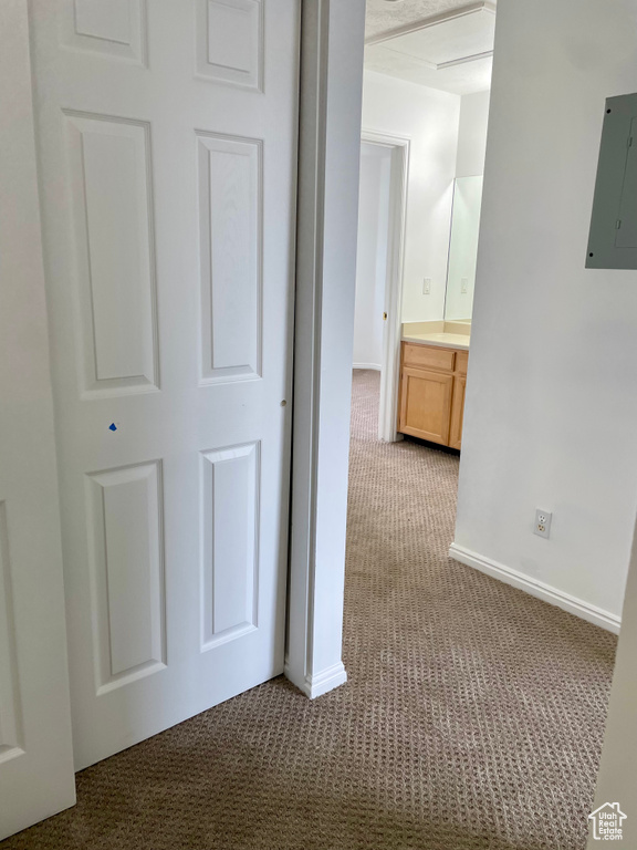 Corridor featuring carpet flooring, electric panel, and baseboards
