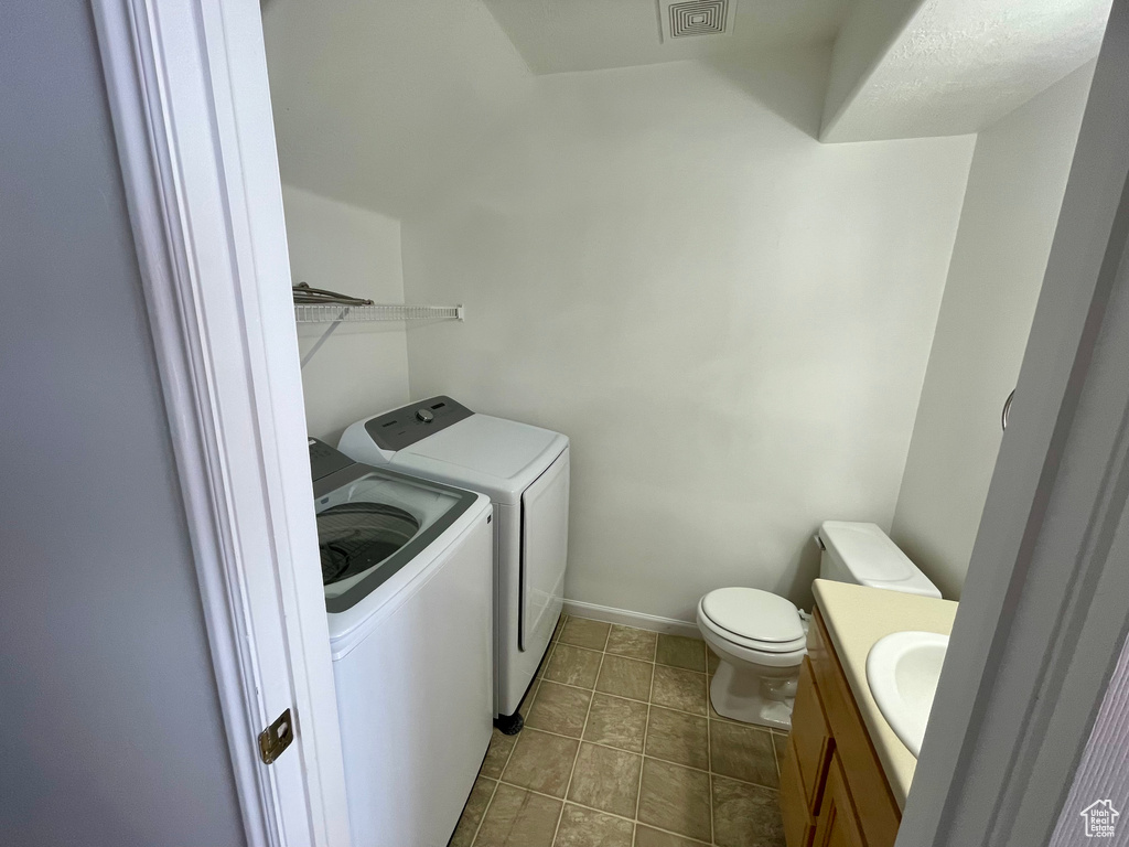 Laundry area featuring separate washer and dryer and tile patterned flooring