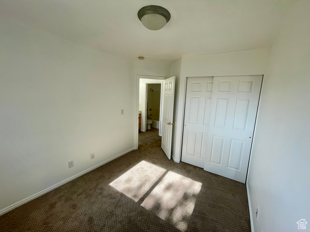 Unfurnished bedroom featuring carpet and a closet