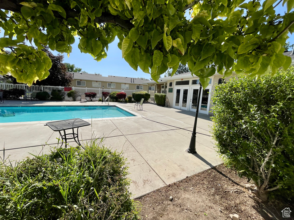 Community pool with french doors and a patio