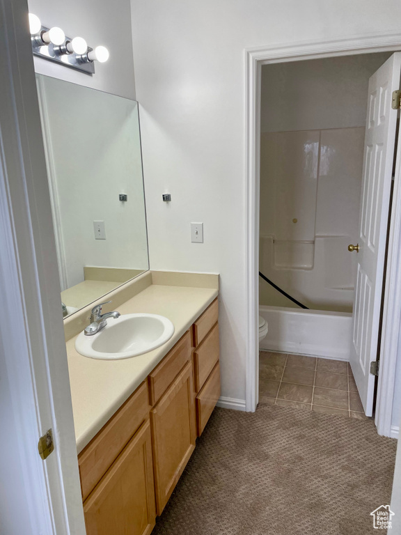 Full bath with vanity, toilet, bathing tub / shower combination, and baseboards