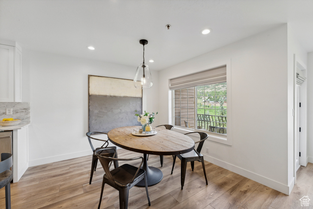 Dining space featuring light wood finished floors, baseboards, and recessed lighting