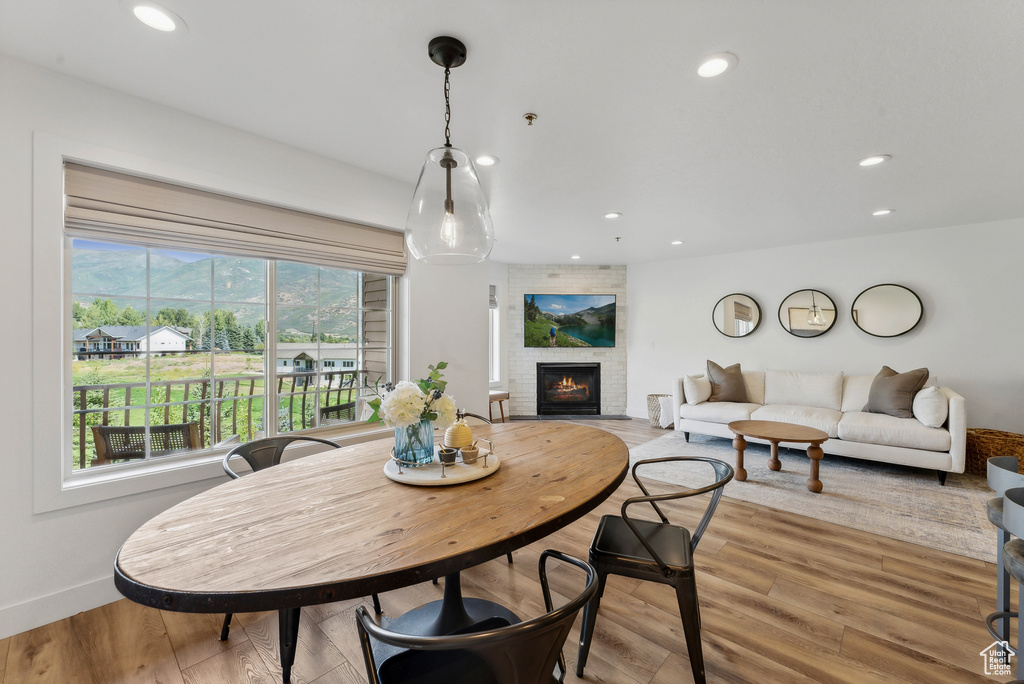 Dining space with recessed lighting, a fireplace, light wood-type flooring, and baseboards