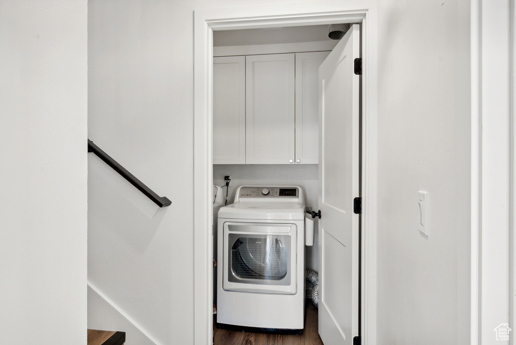 Laundry area featuring washer / clothes dryer, cabinet space, and dark wood finished floors