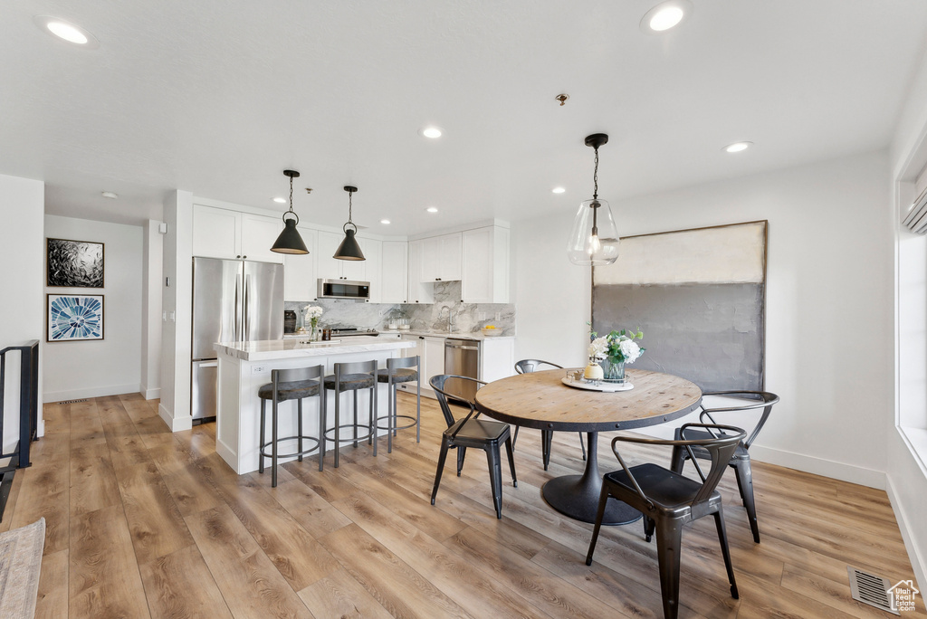 Dining room with recessed lighting, light wood-style floors, and baseboards