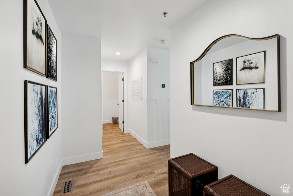 Corridor with light wood-style floors, baseboards, and recessed lighting